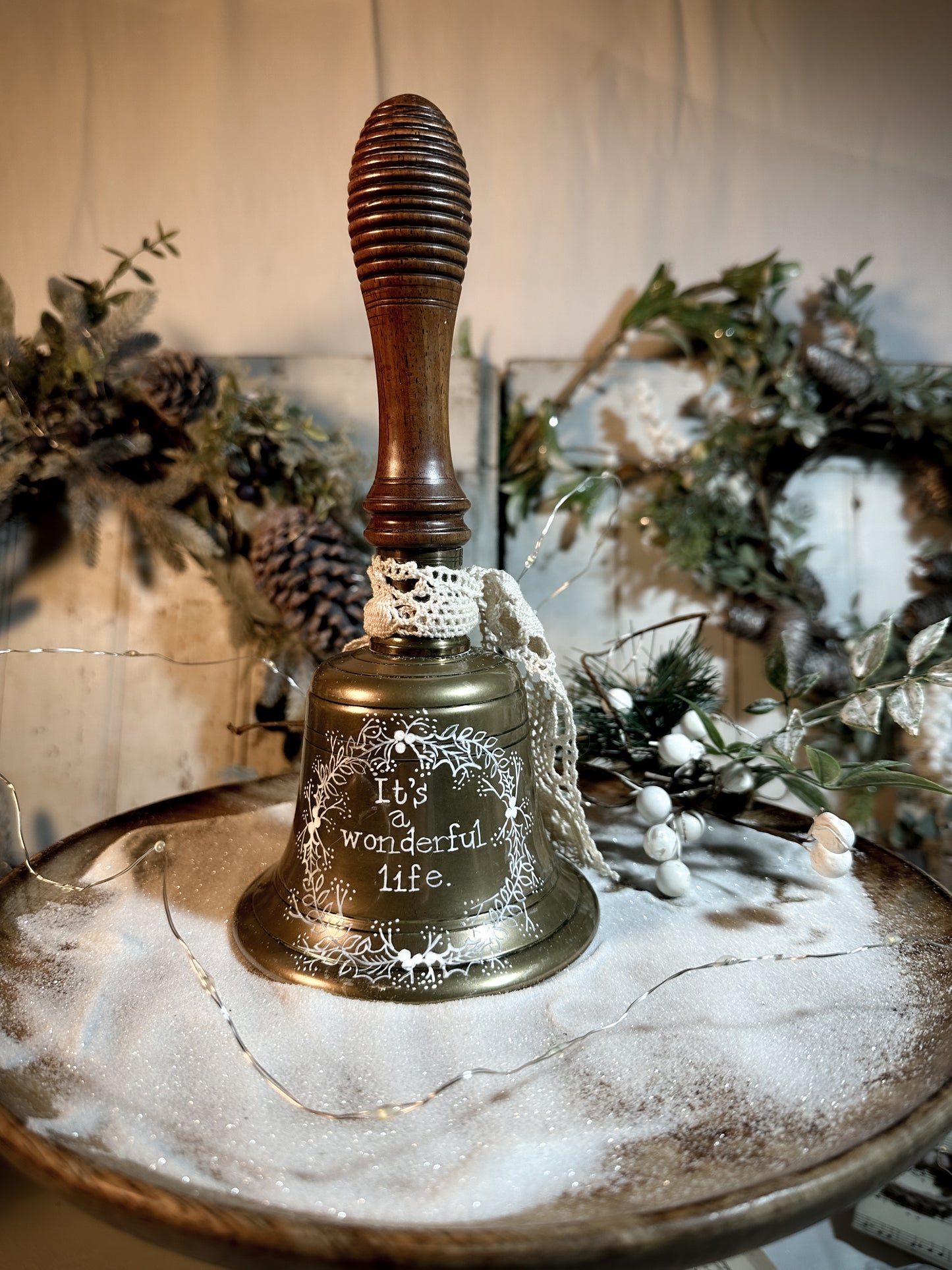 A vintage brass hand held bell with a hand painted quote