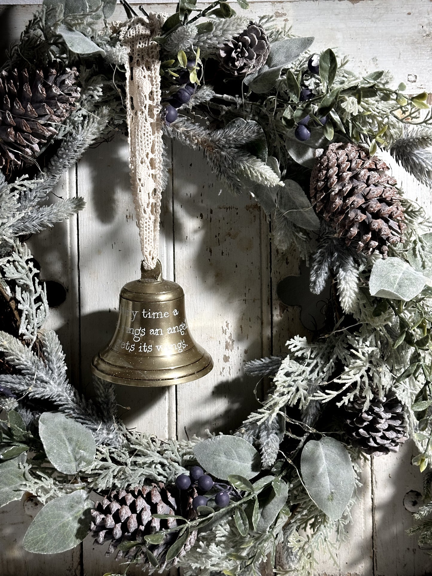 A vintage brass bell with a hand painted quote