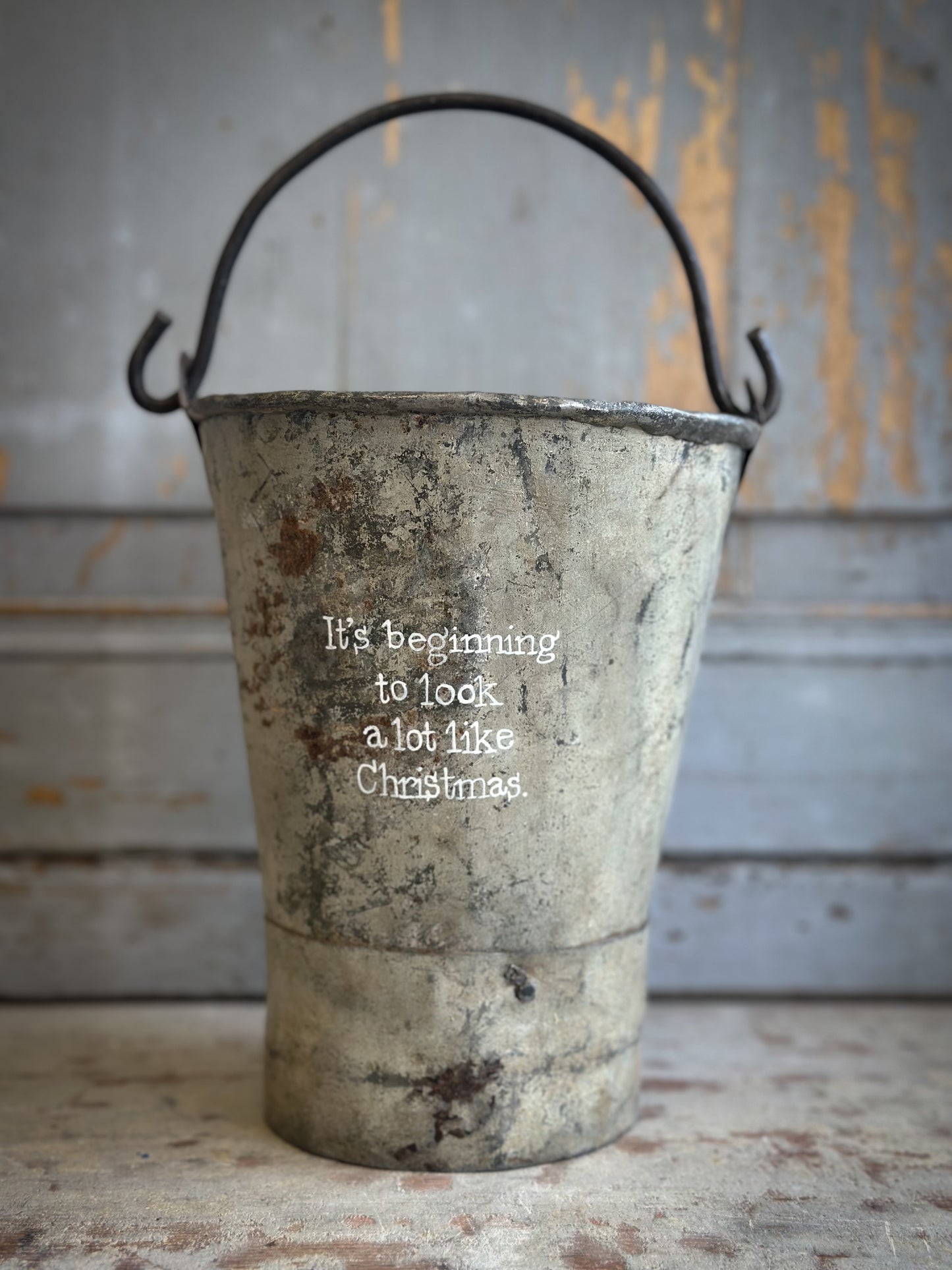 A Recycled Metal Mini Christmas Tree Bucket With A Hand Painted Quote