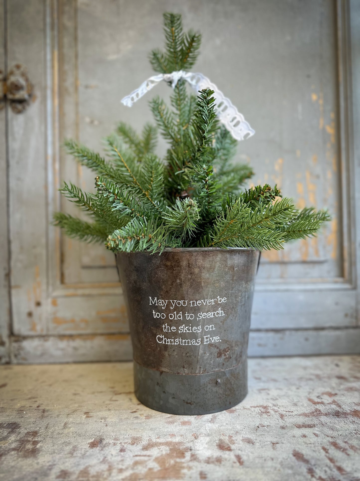 A Recycled Metal Small Christmas Tree Bucket With A Hand Painted Quote