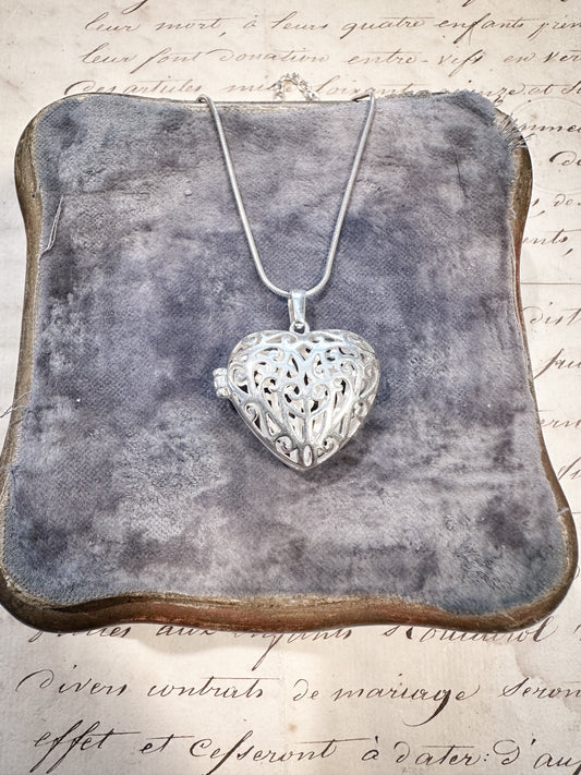 A stunning sterling silver filigree heart locket and chain