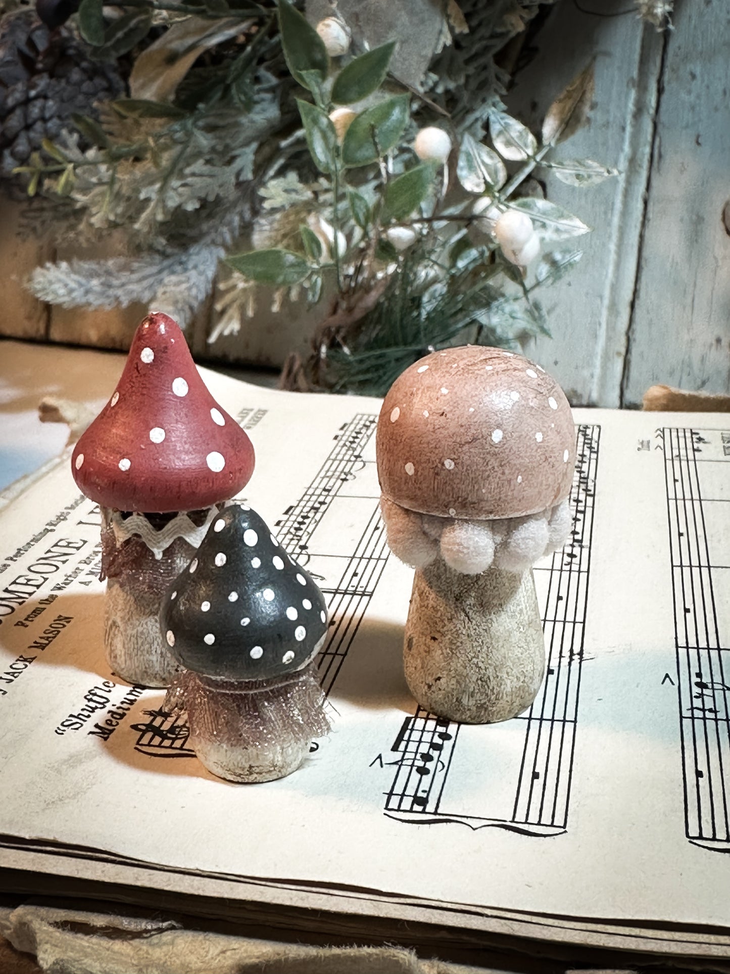 A set of three wooden hand painted and trimmed Christmas village toadstools