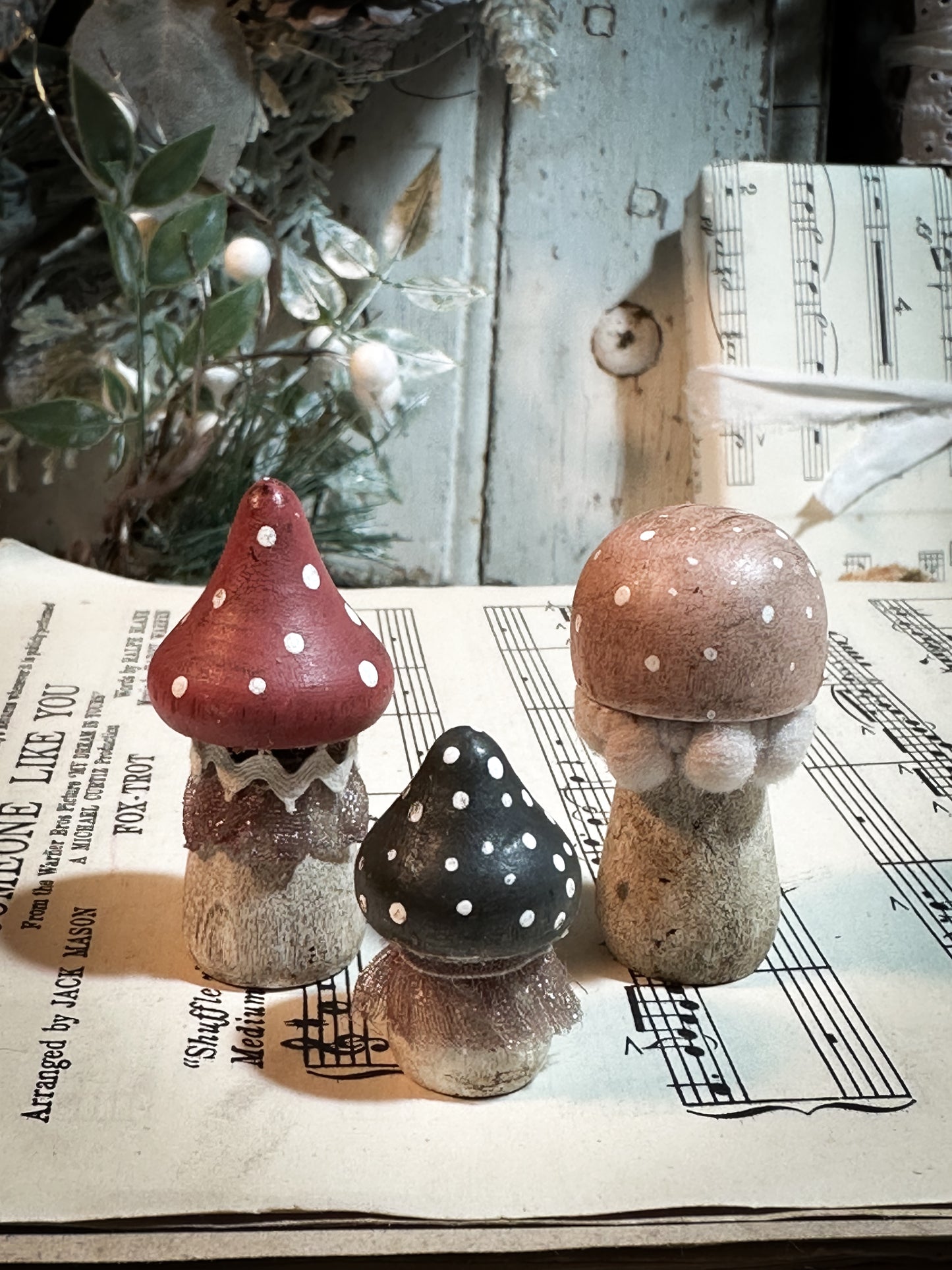 A set of three wooden hand painted and trimmed Christmas village toadstools