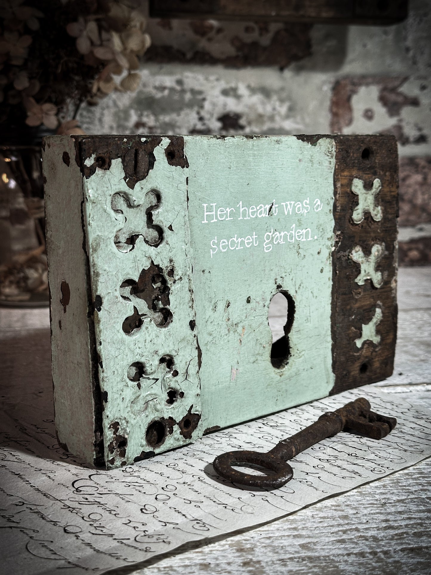 A salvaged original door lock with a painted quote