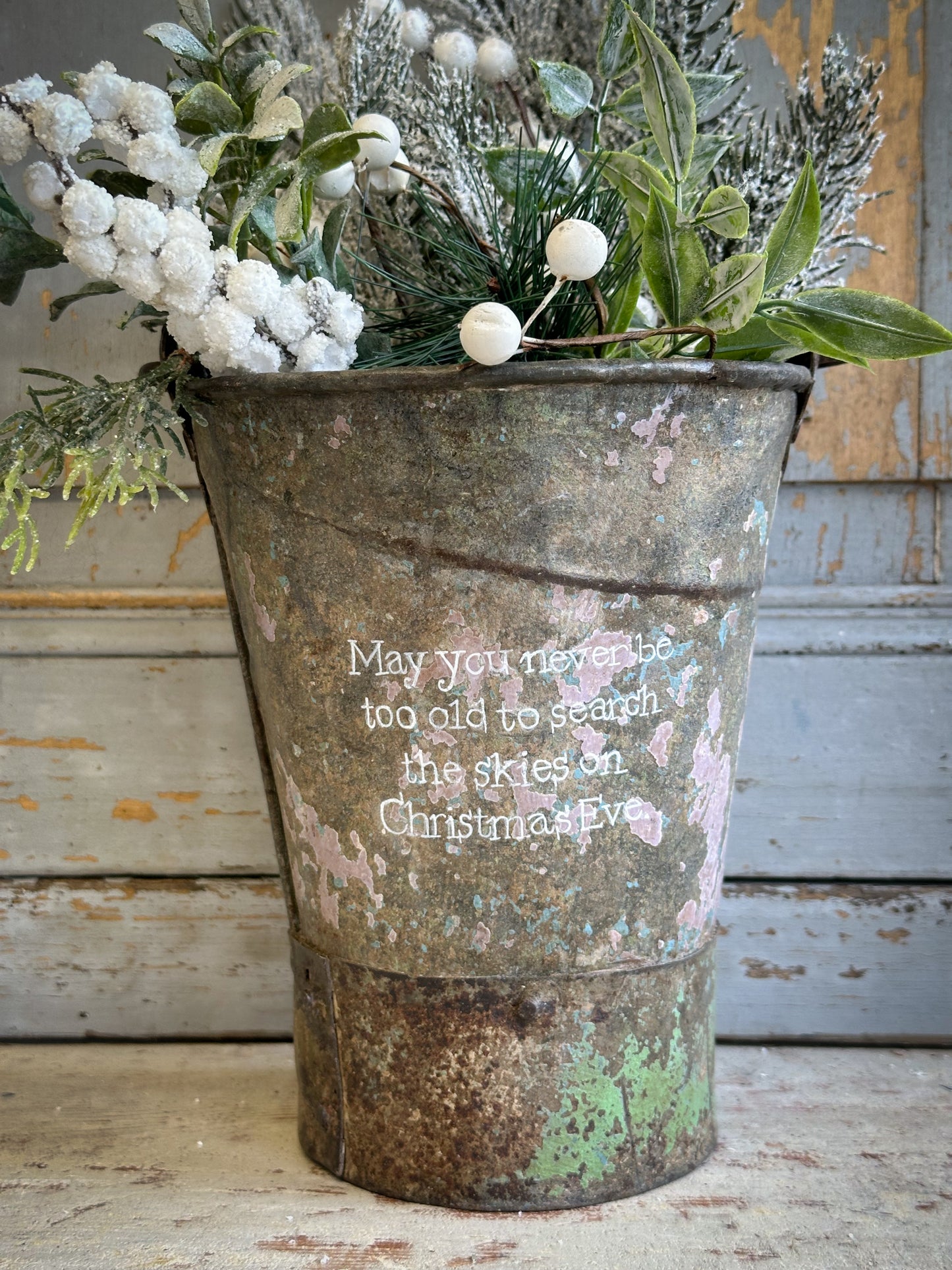 A Recycled Metal Mini Christmas Tree Bucket With A Hand Painted Quote