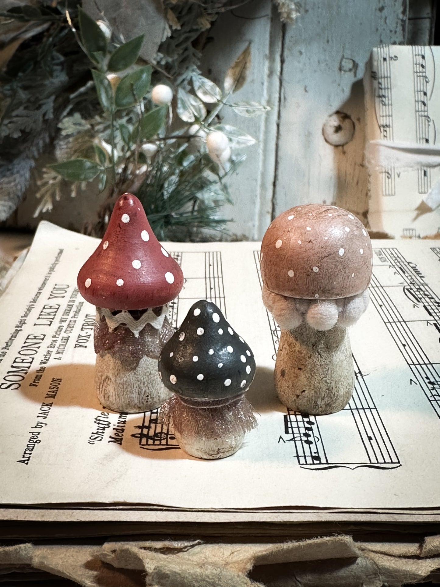 A set of three wooden hand painted and trimmed Christmas village toadstools