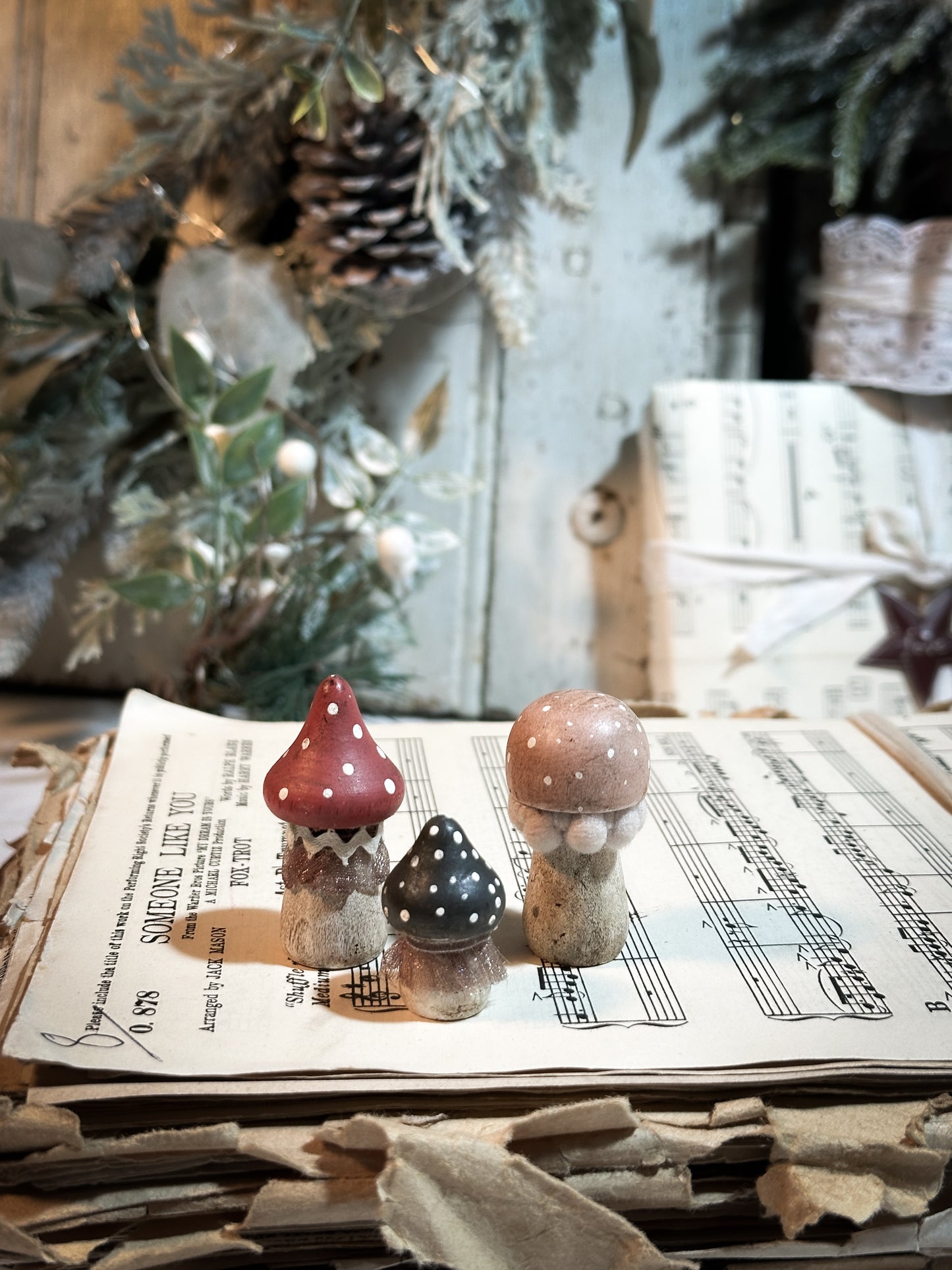 A set of three wooden hand painted and trimmed Christmas village toadstools