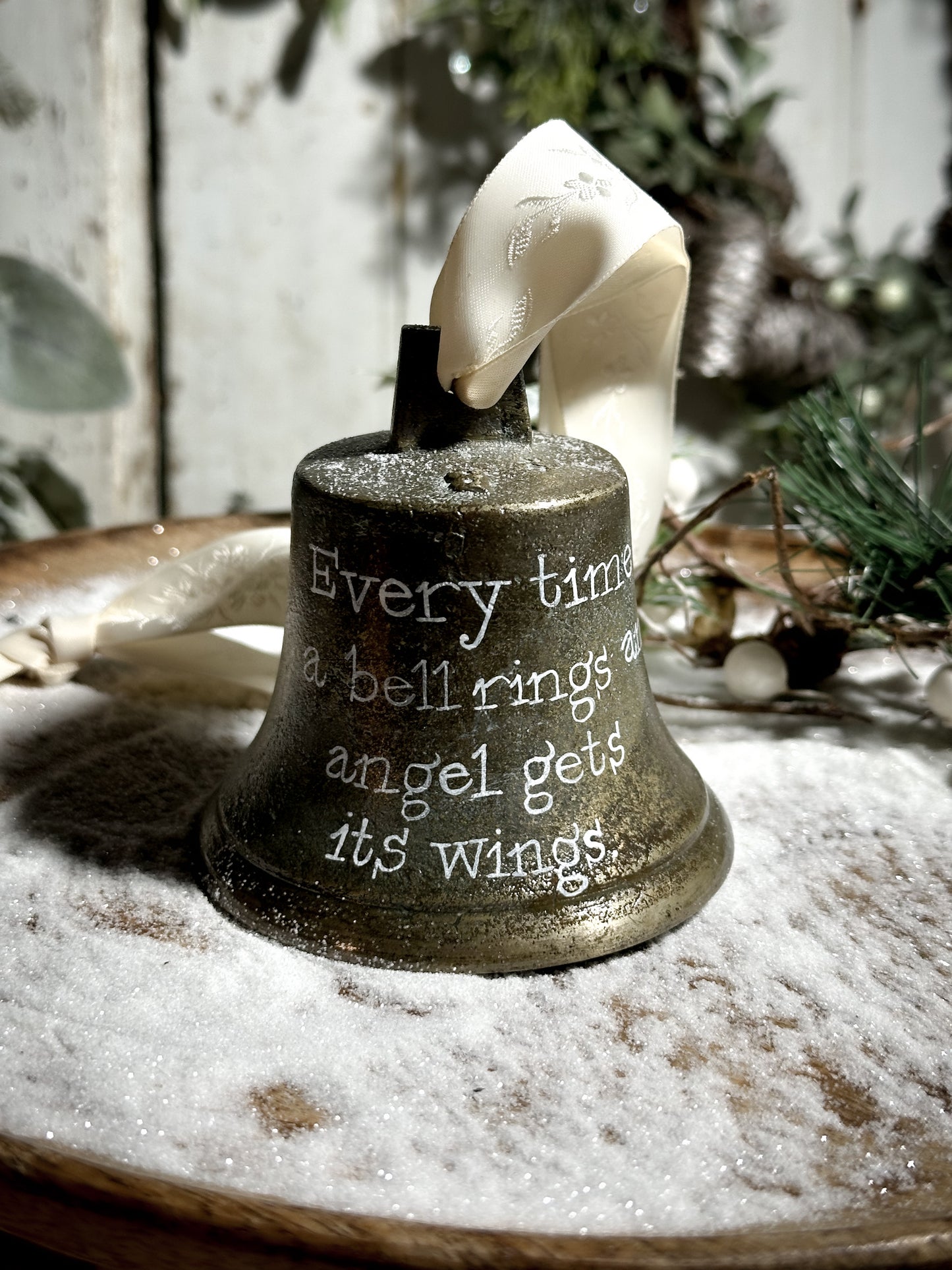 A vintage brass bell with a hand painted quote