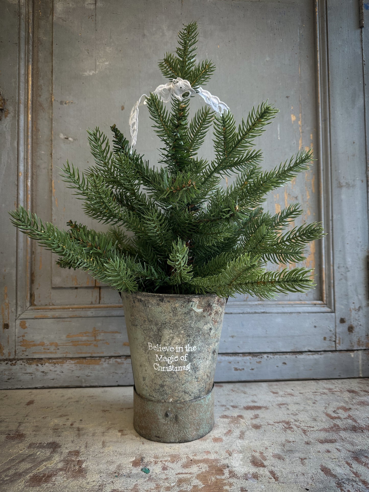 A Recycled Metal Mini Christmas Tree Bucket With A Hand Painted Quote