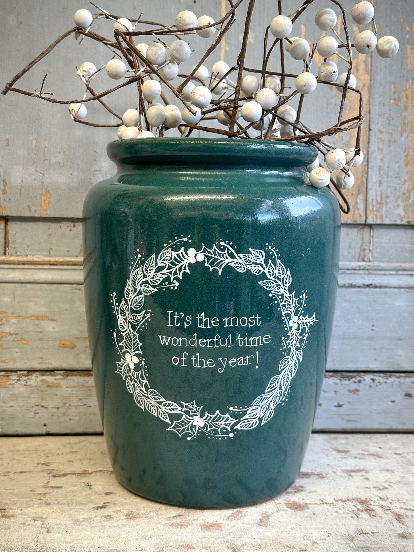 A large Emerald Green Antique Creamery Vase Bottle with a Hand Painted Wreath and Christmas Quote