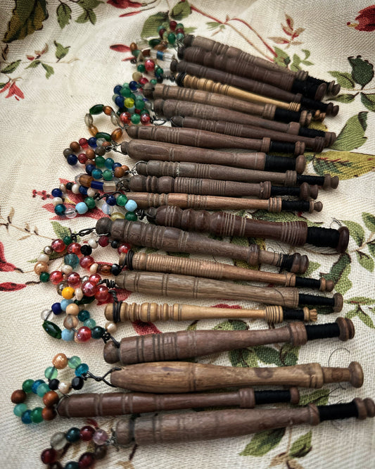 Twenty one beautiful antique wooden lace spindles with spangles from Bedfordshire