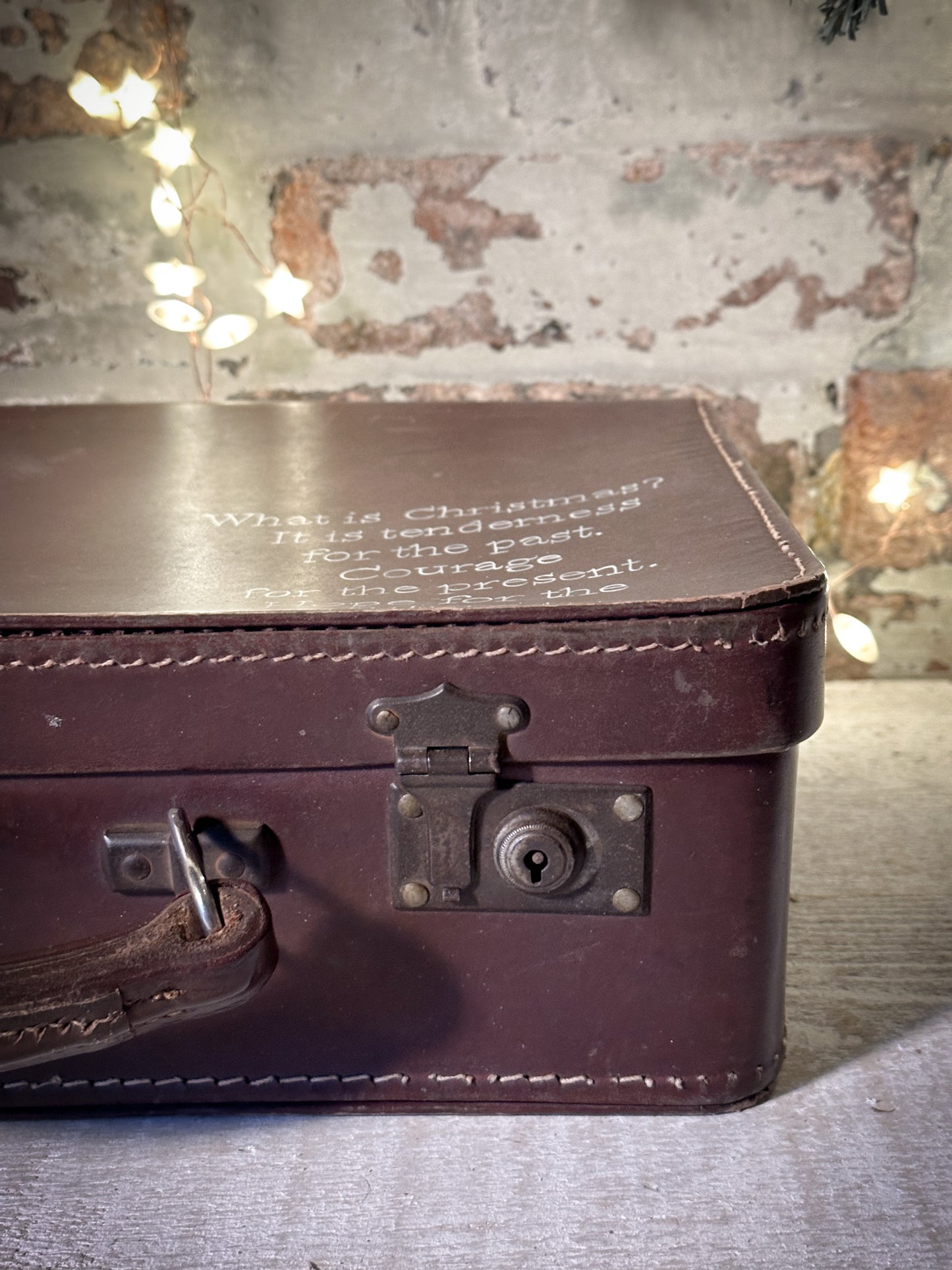 A gorgeous vintage suitcase with a hand painted quote for storing Christmas decorations