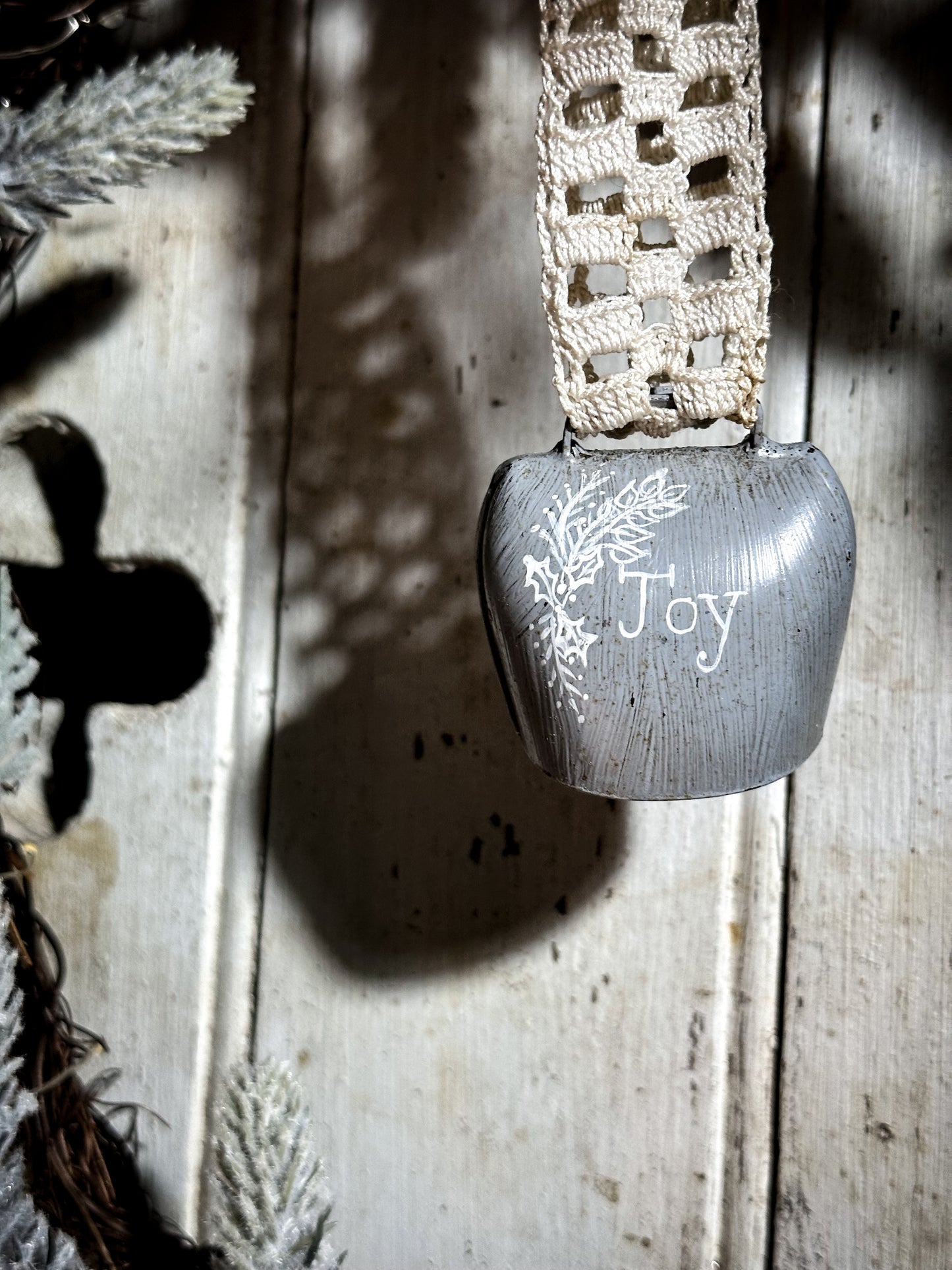 A vintage painted cow bell with a hand painted quote