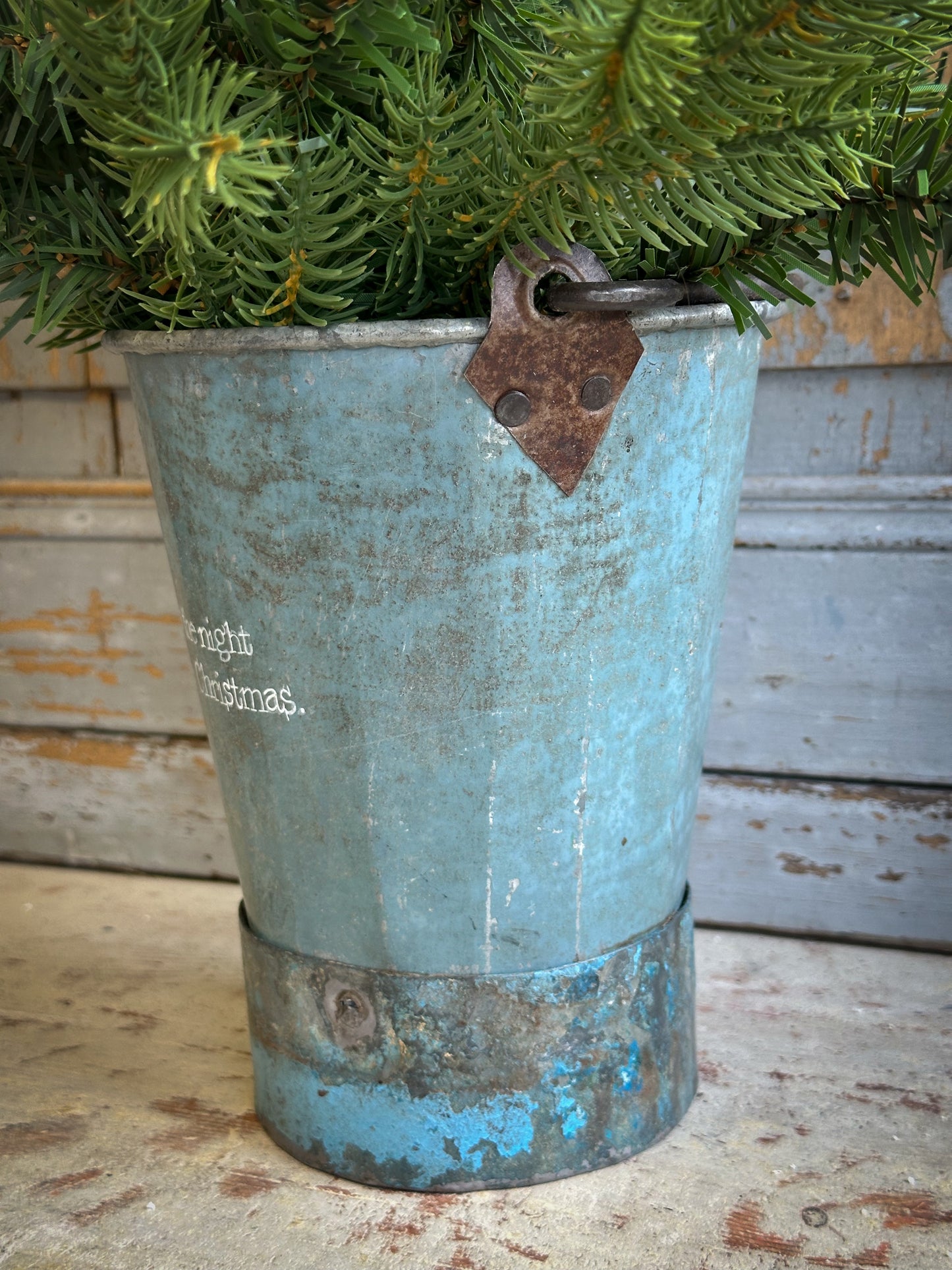 A Recycled Metal Mini Christmas Tree Bucket With A Hand Painted Quote