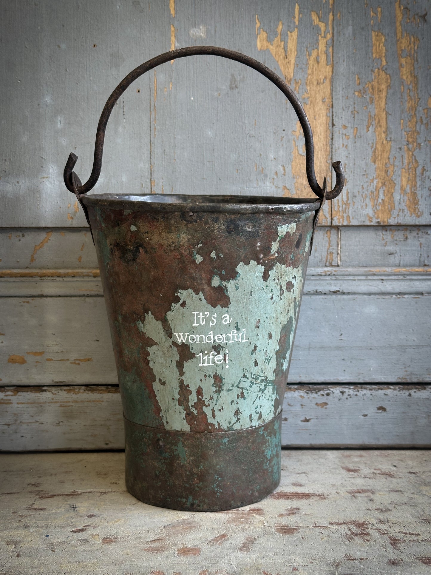 A Recycled Metal Mini Christmas Tree Bucket With A Hand Painted Quote