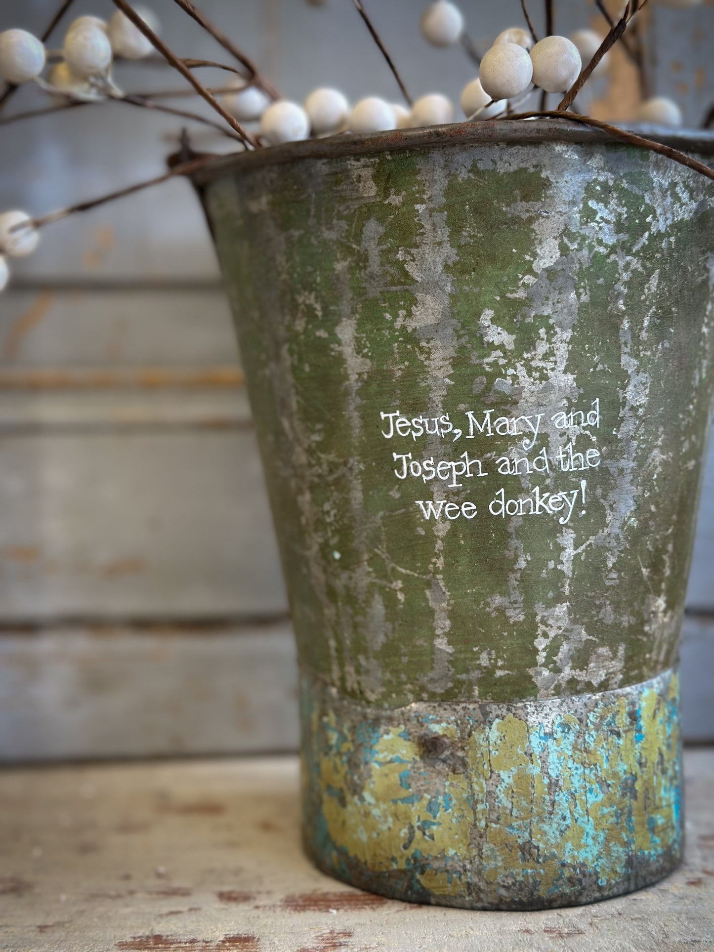 A Recycled Metal Mini Christmas Tree Bucket With A Hand Painted Quote