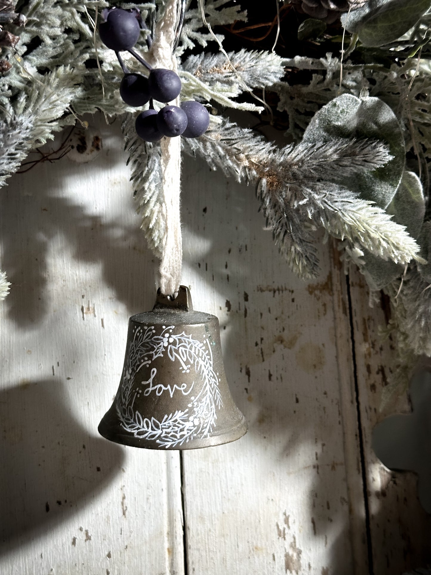 A vintage brass bell with a hand painted quote