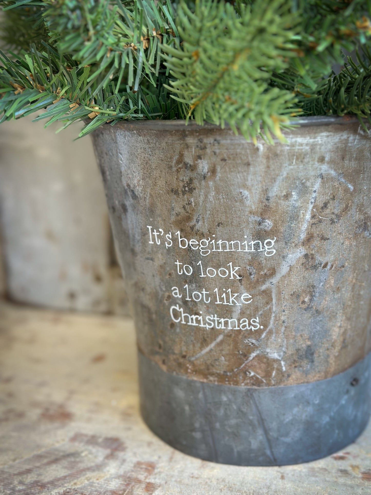 A Recycled Metal Small Christmas Tree Bucket With A Hand Painted Quote